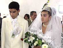 Birita Mihai, 15, and Ana Maria Cioaba, 12, walk into a church during their controversial wedding.